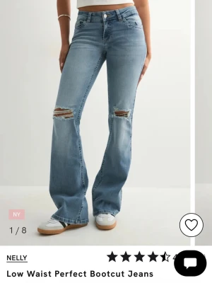 Bootcut jeans med låg midja från Nelly - Snygga ljusblå bootcut jeans från Nelly med låg midja och slitna detaljer över knäna. Jeansen har klassisk femficksdesign och är tillverkade i mjukt denimtyg. Perfekta för en avslappnad och trendig look.