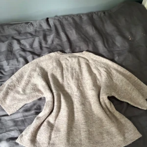 Beige stickad tröja från lager 157 - Säljer en beige stickad tröja från lager 157 i storlek XS. Tröjan har en loose passform med breda, lite kortare ärmar och rund hals. Perfekt för dig som gillar chill och enkel stil. Materialet är mjukt och skönt, passar bra till jeans eller leggings.
