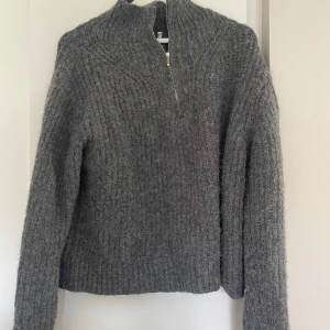 Grå stickad tröja från Weekday - Mysig grå stickad tröja från Weekday med half zip och hög krage. Tröjan har lång ärm och är ribbstickad vilket ger en snygg struktur, nästan aldrig använd 🩶🩶