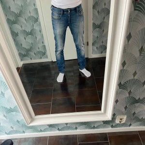 Diesel Sleenker slim-skinny jeans blå - Säljer ett par blå Diesel Sleenker jeans i slim-skinny modell. Jeansen har slitningar och hål på benen för en cool, använd look. Klassisk femficksdesign, stretchigt material och snygg tvätt med ljusa partier. Perfekta för dig som gillar smal passform och streetstil. Jag är 173 och sitter bra. Säljer då jag tröttnat på dem.