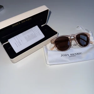 John Henric solglasögon - Säljer nu mina John Henric solglasögon näst intill helt nya använda 2 gånger. Säljs pga att jag inte använder dom alls Alla tillbehör finns, låda,manual,påse och rengöringsduk.  Har man fler frågor eller om det önskas fler bilder så är det bara att skriva.  OBS FINNS UTE PÅ FLER SIDOR