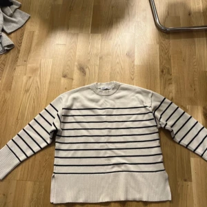 Randig stickad tröja från Zara - Snygg stickad tröja från Zara i beige med svarta horisontella ränder. Tröjan har rund halsringning, långa ärmar och breda ribbade muddar vid ärmslut och nederkant. Nyskick  #zara 