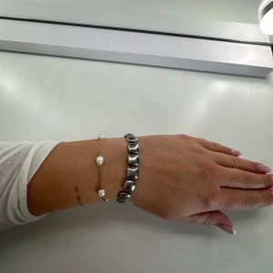Chunky silverfärgat armband - Säljer ett chunky armband i silverfärg med fyrkantiga, blanka länkar. Armbandet har en modern och stilren vibe, perfekt för att lyfta vilken outfit som helst. Justerbar längd med kedja och karbinhake. Passar dig som gillar statement-smycken.