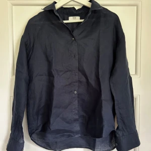 NY- Mörkblå linneskjorta från Uniqlo - En helt ny skjorta från Uniqlo som aldrig är använd. NYPRIS:599kr