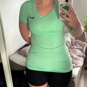 Mintgrön Nike Pro t-shirt XS - Snygg mintgrön Nike Pro t-shirt med v-ringning och korta ärmar. Tight passform som sitter riktigt bra och är perfekt för träning. Köpt på Sellpy och har kvar prislappen❣️I fint men begagnat skick! Storlek XS men passar mig som brukar ha S. Använd gärna köp nu🫶