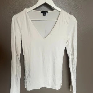 Amisu vit långärmad topp v-ringad strl M - Vit långärmad topp från Amisu med v-ringning.   Mjuk och bekväm passform – enkel att matcha till jeans eller kjol.    Storlek: M   Skick: Mycket fint skick. 
