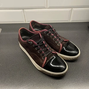 Lanvin cap toe vinröd (bara byten) - Tjena. Vill gärna byta mina lanvin cap toe. Färgen vinröd vilket är en väldigt unik färg och sällsynt färg eftersom dom har slutat producera den typ av färg. Inga större deffekter förutom att det har lossnat en lite del material i insidan av skorna. (Första fotot). Man känner ingen skillnad när man går med dom. Skick 8.7/10. Har inga skor jag är direkt ute efter så skicka gärna skor som är i storlek 44-45. Obs bara skorna hänger med.