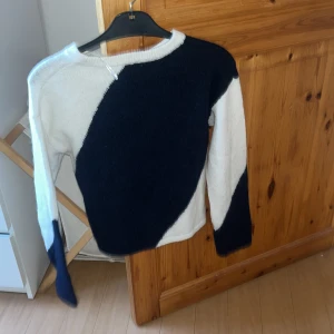 Vit och marinblå stickad tröja - Säljer en snygg stickad tröja i vitt och marinblått med coolt diagonalt mönster. Tröjan har långärmade ärmar och en relaxed passform, perfekt till jeans. PRIS KAN DISKUTERAS 