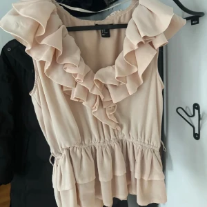 Beige volangtopp med omlott - Supersöt ljusrosa topp från H&M med volanger! Storlek 40 men passar mig som bär S 
