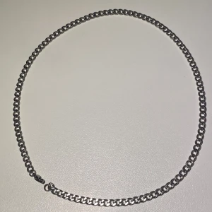 Silver halsband - Minimalistisk och tidlös halskedja i rostfritt stål. Passar både herr och dam och är enkel att bära ensam eller kombinera med andra smycken. Rostfritt stål gör den tålig, slitstark och färgbeständig – perfekt för vardagsbruk. Material: Rostfritt stål Färg: Silver Längd: 50 cm Skick: Nytt