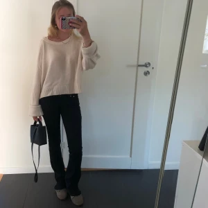 Svarta bootcut jeans - Snygga svarta jeans med bootcut-modell och klassisk femficksdesign. Byxorna har en smal passform upptill och lätt utsvängda ben, vilket ger en tidlös och trendig look. Perfekta att styla med sneakers eller boots.