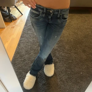 Blå bootcut jeans med slitningar - Snygga blå jeans med bootcut-modell och lätt slitna detaljer på låren. Jeansen har låg midja och är ifrån LTB. Storlek 25/30