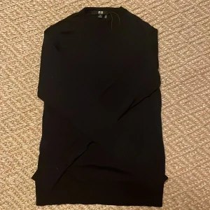 Svart polotröja från Uniqlo XS - En stilren svart polotröja från Uniqlo i storlek XS. Tröjan har lång ärm och en klassisk hög krage. Perfekt att matcha med jeans eller kjol för en clean look. Materialet är mjukt och stretchigt för en bekväm passform.