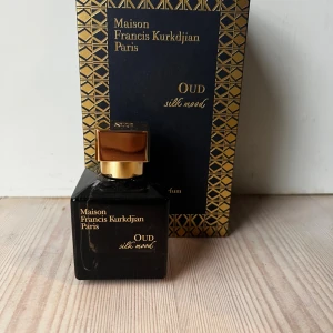 Maison Francis Kurkdjian Oud Silk Mood - Lyxig parfym i svart glasflaska med guldiga detaljer och fyrkantigt lock. Oud Silk Mood är en elegant doft från Maison Francis Kurkdjian Paris, känd för sin exklusiva och sofistikerade känsla. Kommer med originalförpackning i svart och guld.