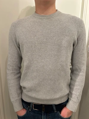 Stickad tröja från Zara - Riktigt snygg stickad tröja från Zara. Den har en snygg gråmelerad färg som passar till alla byxor. Passformen är regular fit och följer kroppen snyggt. Sparsamt använd och är därför i riktigt fint skick! Storleken är S och passar på mig som är 176cm. Tveka inte med att ställa frågor!