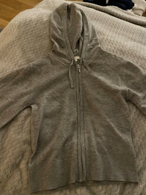 Mjuk skön tröja med zip Gina tricot - Perfekt att ha på sig på sommaren hösten och vintern super mjuk och mysig men en luva och zip en fin grå färg och materialet är super mjukt från Gina tricot.aldrig används. Pris kan ändras på bra förslag