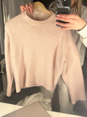 Ljusrosa stickad tröja - Säljer denna super fina och mjuka stickade tröja pågrund av 0 användning! Väldigt väldigt bra skick!