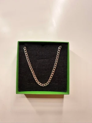 Snygg silverfärgad kedja från Esprit - Stilren och chunky kedja i silverfärg från Esprit. Kedjan har klassisk länkkedje-design och levereras i original grön Esprit-box. Värde över 600kr