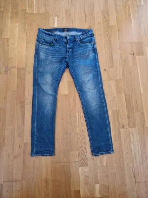 Neuw jeans 36:32 - Säljer ett par Iggy Skinny jeans från Neuw i klassisk blå tvätt. Jeansen har fem fickor, skinny passform och snygga slitningar framtill. Perfekta för dig som gillar en smal siluett och vill ha ett par stilrena jeans i garderoben. Jeansen är i mycket bra kvalitet och har inte använts så mycket !