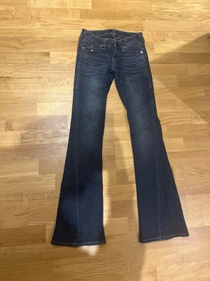 True Religion med Glitter - True Religion Joey Low Rise Flare – strl 23  Säljer ett par True Religion-jeans i modellen Joey Low Rise Flare. Klassisk flare-modell med låg midja. Nu pris 1399kr mitt pris 1000kr. Jeansen har dekorativa glittrande detaljer i sömmarna framtill (syns på bilderna). Vissa av dessa små glitter/paljett­detaljer har lossnat med tiden, men det är inget som ger tydliga märken eller skador – inget som sticker ut när man har dem på sig. Hör av dig för fler bilder eller om du har några frågor!💕