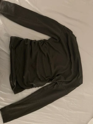 Grå långärmad  - En enkel grå topp med lång ärm. Tunn och mjuk i materialet, perfekt att styla lager på lager eller bära som den är. Det är en clean look och toppen har en smal passform.