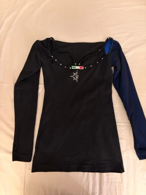 Karisma titta top svart med blå arm - Säljer min svarta konståkning tröja från karisma. Den har en mörkblå arm och resten av tröjan svart. Har använt den över ett år och använt många gånger men den är i forfarande väldigt bra skick och har inga defekter. Alla kristaller sitter kvar och gå och använda mycket mer. Har storlek XS Adult. Modellen på tröjan är karisma titta top. Köpte tröjan för 1600kr så säljer den för 450kr