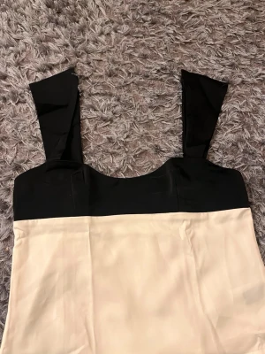 Svart och vit linnetopp med breda band - Säljer en linnetopp från cider i svart och vitt med breda axelband och rak passform. Säljer pga för stor, aldrig använd.