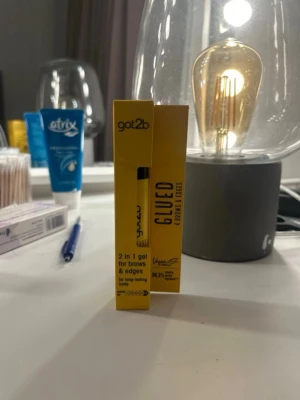 got2b Glued 2 in 1 gel för bryn - Säljer en got2b Glued 2 in 1 gel för bryn och edges. Transparent gel i gul tub med svart lock, vegansk formula och 16 ml. Perfekt för att forma och styla ögonbryn och babyhår med långvarigt resultat. Enkel att applicera med borste.