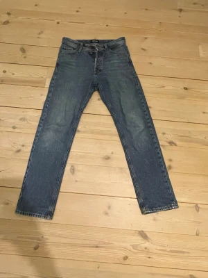 Säljer ett par blåa jeans från Jack & Jones - Blåa Jack & Jones jeans säljes. Modell: Relaxed/Chris. Det är ett litet hål på vänster ficka men annars är allt bra. Om ni har frågor är det bara att skriva. 
