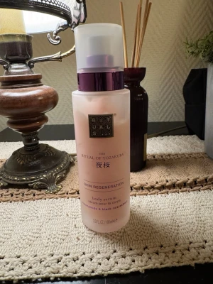 Rituals The Ritual of Yozakura body serum - Använd fåtal gånger. Säljer en lyxig body serum från Rituals, The Ritual of Yozakura. Flaskan är frostad rosa med lila pump och lock. Innehåller niacinamid och extrakt av svart ris för hudförnyelse. Volymen är 100 ml och designen känns exklusiv och modern.