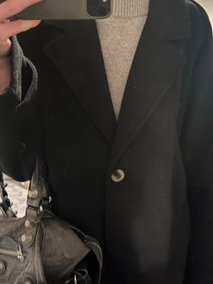 Svart kappa - Säljer denna oversized svarta kappan med perfekt passform😍 Endast använd några få gånger så nästan helt ny, fick den i present och säljer då jag har en liknande🤍 nypris 800kr