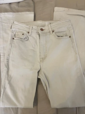 Bootcut vita jeans - Bootcut jeans i ljusvit denim från &Denim. Hög midja och klassisk femficksmodell med snygga kopparfärgade nitar. Sitter som om de vore lågmidjade. Perfekta för dig som gillar en retroinspirerad look med lite vidare ben. Styla med sneakers eller boots för en clean vibe.