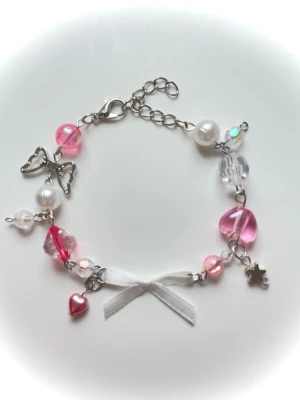 Sött armband med pärlor och rosett - Handgjort armband med pärlor och berlocker med en rosett🥰liten gåva på köpen och kolla min profil för mer🦄