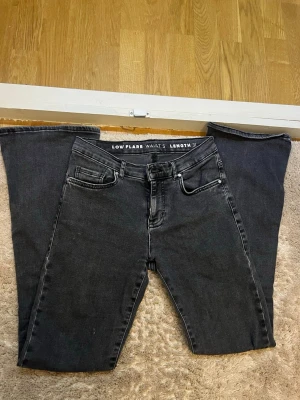 Svarta low flare jeans - Säljer ett par svarta low flare jeans med låg midja och utsvängda ben. Jeansen har klassisk femficksdesign och är i ett mjukt denimtyg, lite strechigt. Sitter bra på mig som är 167. Längden är 31