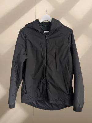 Svart lättviktsjacka från Sail Racing - Sail Racing Spray Primaloft, Svart kvalitetsjacka. Fodrad med syntetdun. Vind- och vattenavvisande Primaloft teknologi. Jackan har en clean look med diskreta loggor, huva och dragkedja framtill. 