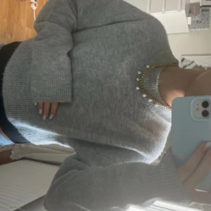 Grå stickad tröja från Zara - Mysig grå stickad tröja från Zara med rund halsringning och ribbade muddar vid ärmslut och nederkant. Långärmad och i en loose passform. Knappt använt och köptes för ca 400kr. Lite kortare passform 