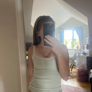 Ljusgrön ribbad linnetopp med spets H&M - Supersöt ljusgrön  ribbad linnetopp från H&M Basic med smala axelband och fin spetskant upptill. Perfekt att styla med jeans eller kjol för en fräsch look. Mjuk och stretchig bomullskänsla som sitter tajt och bekvämt.