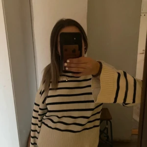 Randig stickad tröja från NA-KD - Säljer en vit och svart randig stickad tröja från NA-KD i storlek S.  Tröjan är varsamt använd och är perfekt nu till vintern. Hör av er om ni har några frågor. Skickar snabbt💞