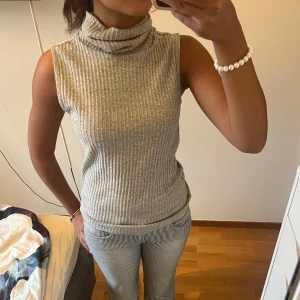 Grå ribbad polotopp från Visual Clothing Project - Säljer en grå ribbad polotopp från Visual Clothing Project i storlek S. Toppen är ärmlös med polokrage! 