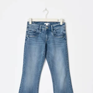 Blå bootcut jeans med låg midja - Blåa jeans som är använd 2 gånger. Lowwaist och är i storlek 158, passar mig som har storlek Xs/S