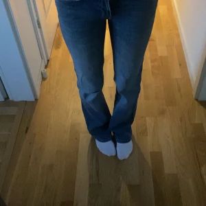 Bootcut jeans 90's från 157, XXS - Snygga ljusblå bootcut jeans från 157 i modellen 90's Boot. Klassisk femficksdesign med knappar på bakfickorna och full längd. Jeansen har en skön passform och är tillverkade i mjukt denimtyg. Perfekta för dig som gillar retrovibbar och stilren look.