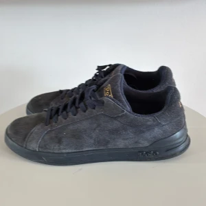 Mörkblå mockasneakers från Polo Ralph Lauren - Snygga mörkblå sneakers från Polo Ralph Lauren i mjuk mocka med matchande mörkblå snörning och diskret logga på sidan. Skorna har en klassisk låg profil och svart sula, perfekta för en clean och stilren look.