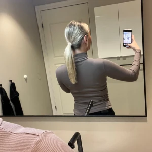 Beige ribbad polotröja - Säljer en beige ribbad polotröja med lång ärm och tight passform, sitter som en xs-s