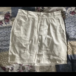 Vit kortkjol med snörning från ONLY - Supersöt vit kortkjol från ONLY med snörning i midjan och praktiska fickor. Kjolen har bälteshällor och är gjord i mjukt bomullsmaterial, perfekt för en chill och avslappnad look. Bild nummer 4 har jag gjort tagit in kjolen så den blir kortare på bild nummer 5 har jag den normalt 