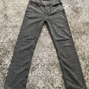Grå jeans Montén första drop, storlek 30/32 - Snygga grå jeans från Montén med klassisk femficksdesign och raka ben. Jeansen har kontrastsömmar och en cool grön patch bak med texten 'Classic Way of Life'. Aldrig använd och sitter på som bara den
