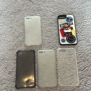 iPhone 7/8 Plus skal, 5-pack - Fem skal till iPhone 7/8 Plus: fyra transparenta/matta och ett dekorerat med klistermärken. Skalen är i gott begagnat skick, vissa med mindre missfärgning. Perfekt för att skydda din mobil och variera utseendet.
