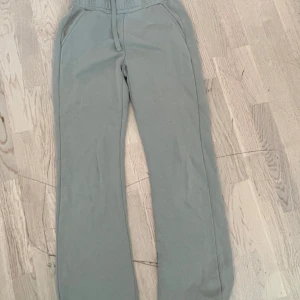 Gröna mjukisbyxor från Kappahl S - Mysiga grå mjukisbyxor från Kappahl i storlek S. Byxorna har resår och snörning i midjan samt fickor på sidorna. Perfekta för chill dagar eller när du vill vara bekväm. Materialet är mjukt och skönt mot huden.