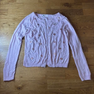 Tunn kofta  - Rosa kofta med knappar och paljetter! Storlek 134/140. Ett hål på armen och 2 små hål under varje liten arm 