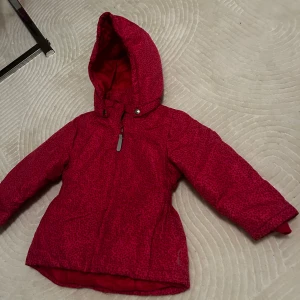 Rosa leopardmönstrad jacka - Snygg rosa vinterjacka från Name It i storlek 98. Jackan har leopardmönster, huva och dragkedja framtill. Perfekt för kalla dagar. 