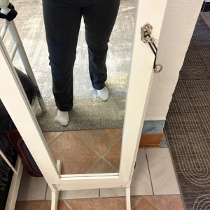 Svarta raka jeans med hög midja - Säljer ett par svarta jeans med hög midja och raka ben. Jeansen har klassisk femficksdesign och är tillverkade i ett mjukt denimtyg. Perfekta för dig som gillar en enkel och stilren look. Knappt använda.